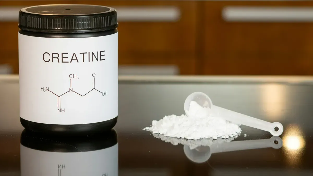 Creatine supplement bottle with a woman exercising in the background