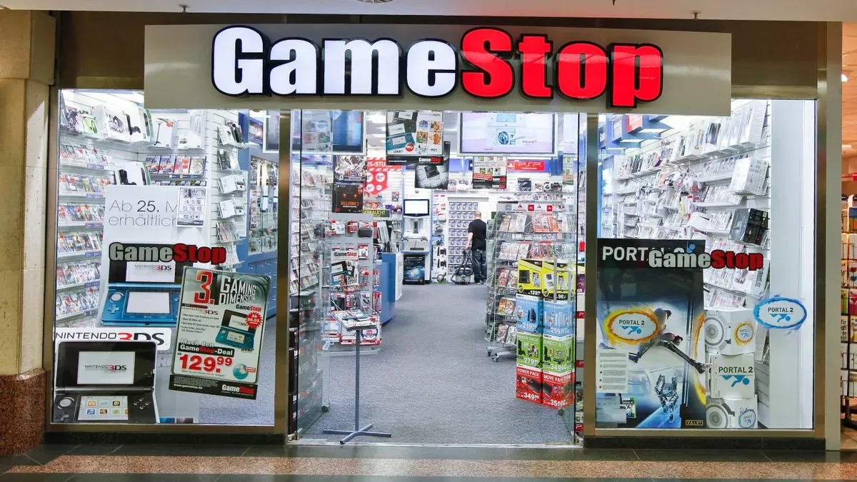 GameStop store closure sign with employees and customers in the background
