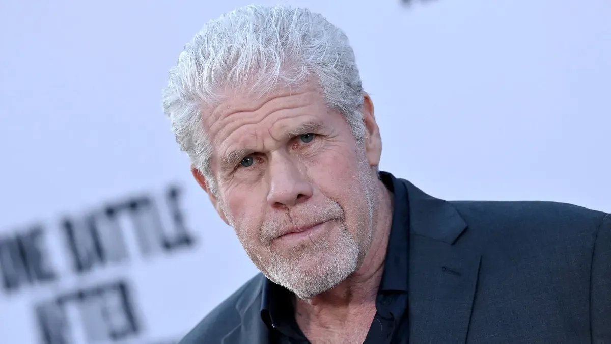 Ron Perlman in a studio, holding a sandwich, recording Fallout's iconic intro line.